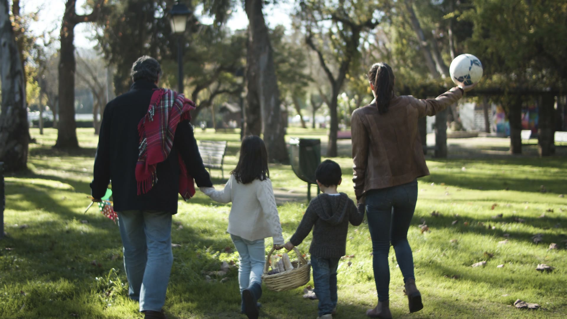 Una familia camina por un parque una tarde de sol